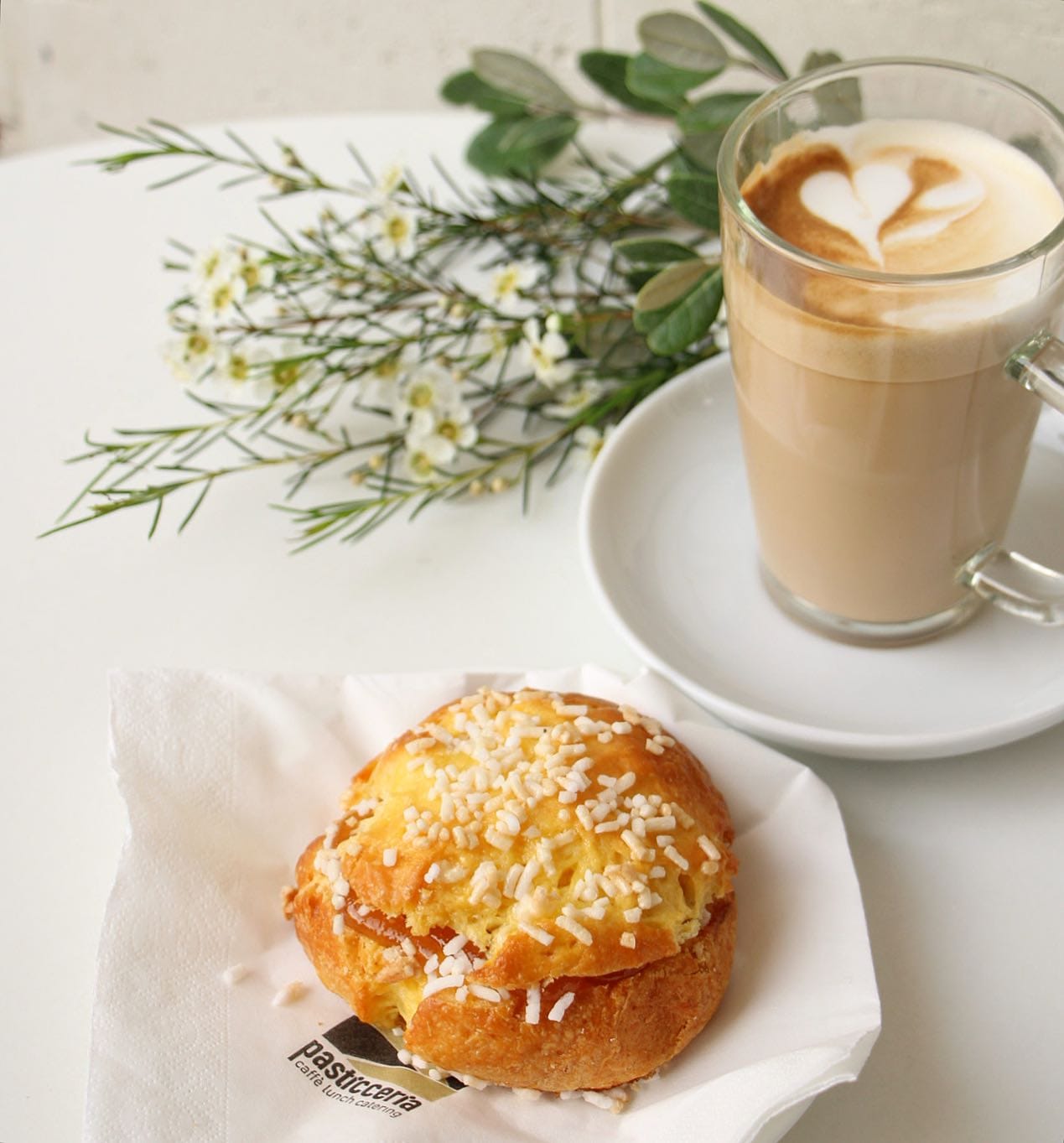 Brioche e caffè su tavolo con tovagliolo Pasticceria Perla