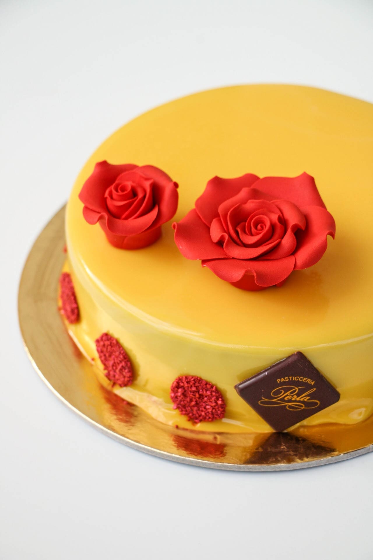 Torta glassata gialla con rose di zucchero