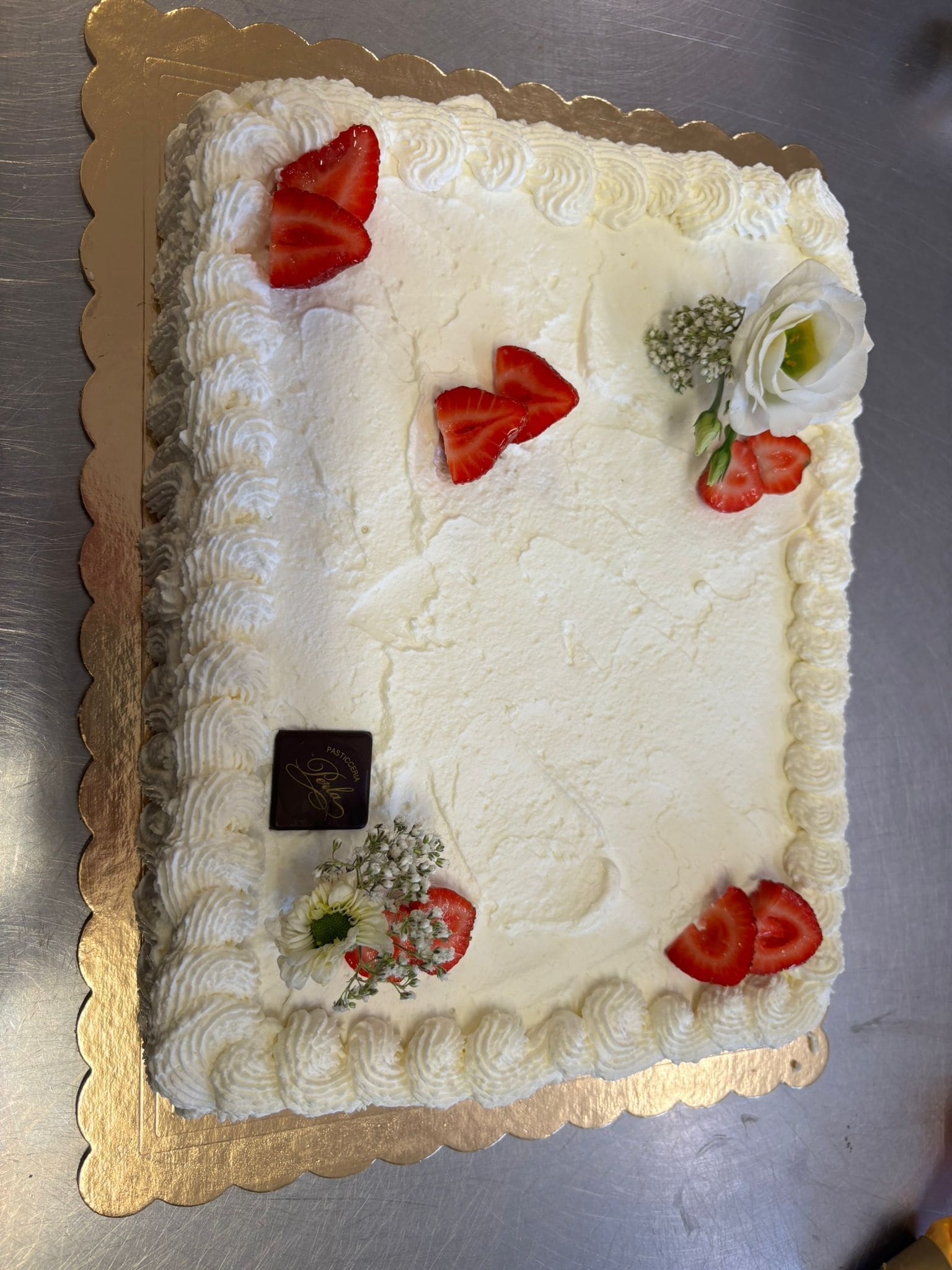 Dettaglio torta nuziale con rose e lamponi