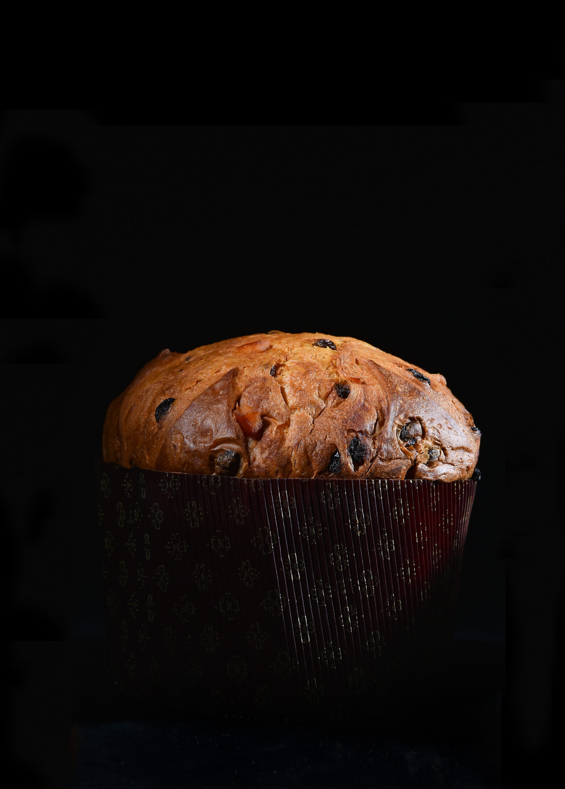 artisanal panettone typical from Milano area on black background whit cutting light